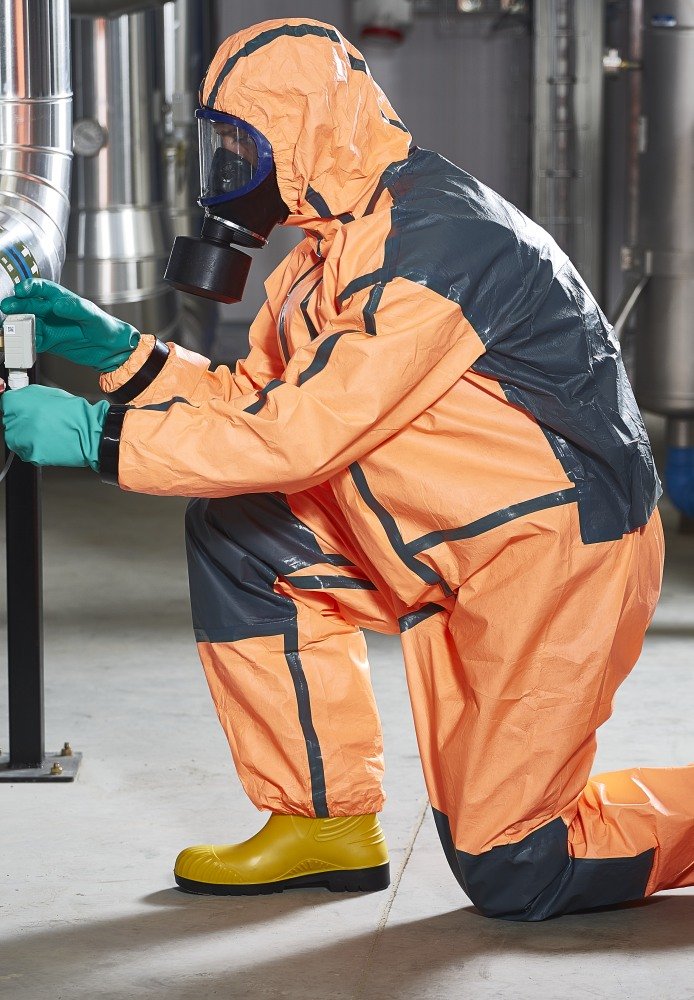 Opérateur portant combinaison, gants et masque pour limiter les risques évacuation produits chimiques.