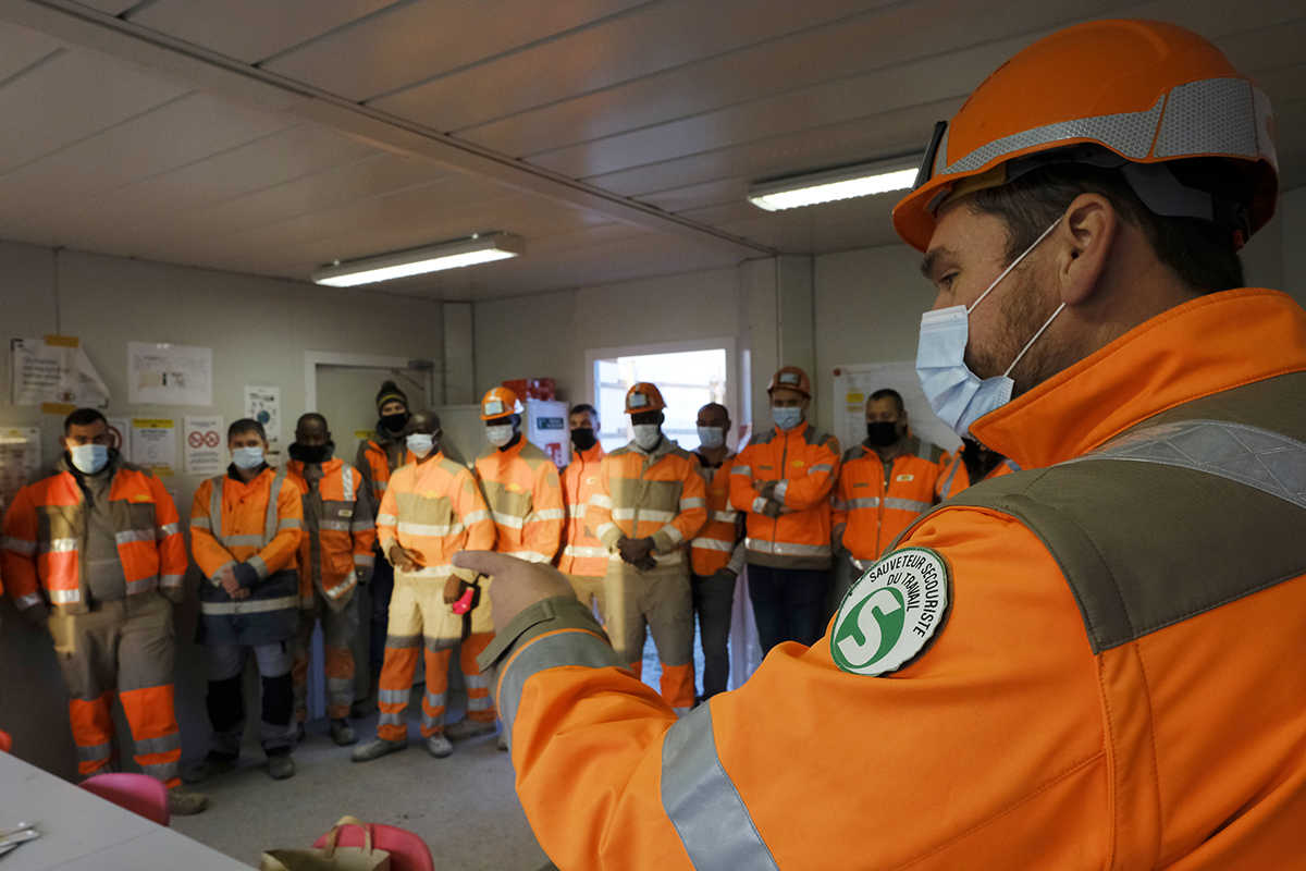 Managers et ouvriers discutant pour comprendre et réussir sa démarche préventive sur un chantier.