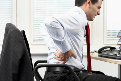 Image d'un travailleur à son bureau présentant des symptômes de mauvaise posture de travail.